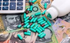 Pills with a calculator on Australian banknotes.
